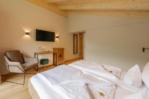 萨尔巴赫Haus Jausern的卧室配有白色的床和椅子