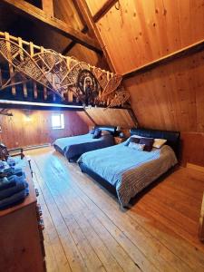 Saint-Laurent-de-l'ile d'Orleans勒皮蒂特博纳尔旅舍的一间卧室设有两张床和木制天花板
