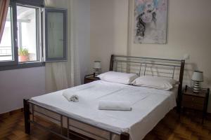 毕达哥利翁Spacious Apartment in the heart of Pythagorion的一间卧室配有一张带白色床单的大床