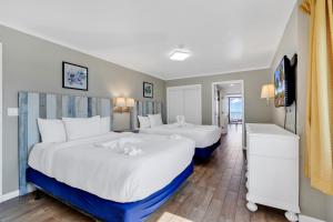 默特尔比奇Beachfront Luxury Condo w Private Balcony的白色和蓝色的酒店客房内的两张床