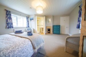 布德Penrose Cottage的一间卧室设有一张床和一个壁炉。