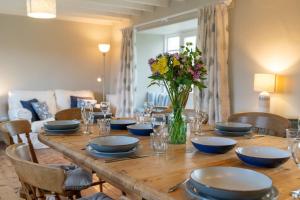 布德Penrose Cottage的一张带蓝色菜肴和花瓶的木桌