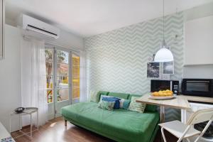 塔维拉Apartamento Lima - Tavira的客厅设有绿色沙发,厨房设有绿色沙发