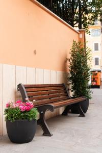 罗马Major House - Luxury Apartments的木凳,坐在鲜花盛开的墙上