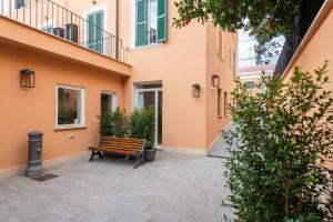 罗马Major House - Luxury Apartments的坐在建筑物庭院的长凳