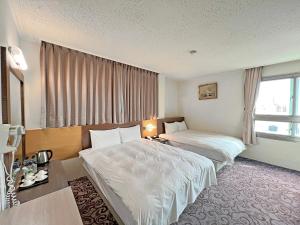 马公丰国大饭店的酒店客房设有两张床和窗户。