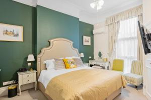 托基金斯顿宾馆的一间卧室设有一张床和绿色的墙壁