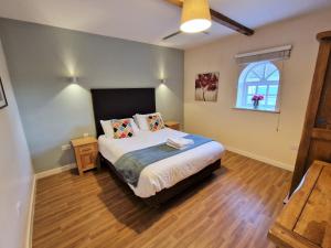 莱顿巴泽德Barley End的一间卧室设有一张大床和一个窗户。