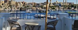 阿斯旺La Terrace的阳台配有两把椅子,享有海港景色