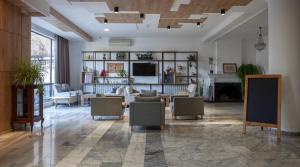 第比利斯阿连斯酒店的客厅配有沙发、椅子和壁炉