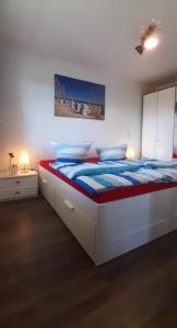 卡尔斯哈根Ferienapartment Wellenreiter Insel Usedom的白色卧室配有一张带蓝色床单的大床