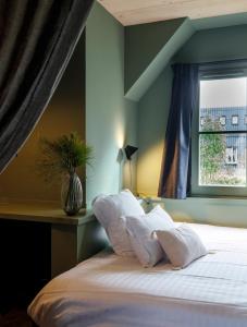 肖蒙索卢尔Le Bois des Chambres的卧室配有一张带白色枕头的床,卧室设有窗户