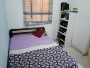 普拉亚Borges Place的小卧室配有一张带紫色床单的床和窗户