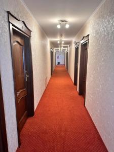 Lubycza KrólewskaHotel "XAVIER"的走廊上铺有红地毯的走廊