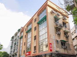 艾哈迈达巴德OYO Hotel Shubham Inn的建筑的侧面有很多窗户