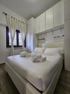 罗马ROME HOLIDAY QUIET AND CONFORTABLE APARTMENT的白色卧室配有一张带白色橱柜的大床