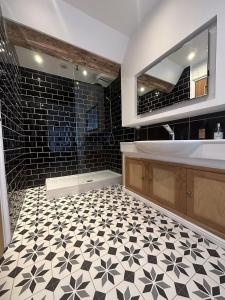 巴斯洛The Beeches - Chatsworth Apartment No 5 - Sleep2的浴室铺有黑白瓷砖地板,配有浴缸。