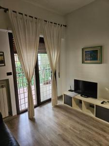 罗马ROME HOLIDAY QUIET AND CONFORTABLE APARTMENT的一间带电视和大窗户的客厅