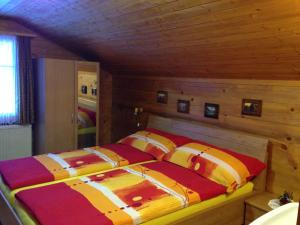 埃尔嫩Ferienwohnung Haus Mühlebach的木制客房内的一间卧室,配有一张床