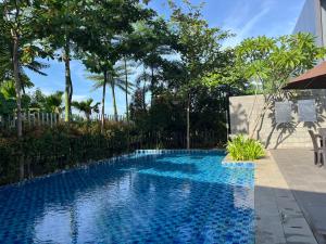 雅加达2 Floor Cozy House in Wisteria Jakarta Garden City的一座树木繁茂的庭院内的游泳池