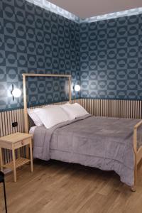 那不勒斯Palazzo Ferrara的一间卧室设有一张床和蓝色的墙壁