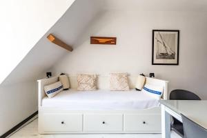 迪纳尔Le Capucin - Petit duplex avec place de parking的卧室配有白色的床和书桌