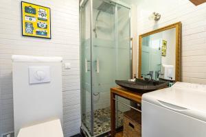 迪纳尔Le Capucin - Petit duplex avec place de parking的一间带水槽和玻璃淋浴的浴室