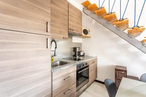 迪纳尔Le Capucin - Petit duplex avec place de parking的一间带木制橱柜和楼梯的厨房