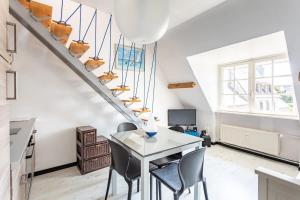 迪纳尔Le Capucin - Petit duplex avec place de parking的一间带桌椅和楼梯的用餐室