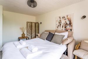 迪纳尔Saint Alexandre - Jolie maison atypique -Terrasse的一张白色的床,位于一个配有沙发的房间
