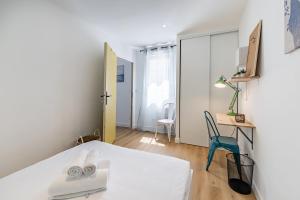 圣雅克德拉朗德L'ANTHRACITE, apartement rénové, tout confort的卧室配有白色的床和蓝色椅子