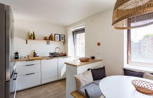 迪纳尔Saint Alexandre - Jolie maison atypique -Terrasse的厨房配有白色橱柜和桌子