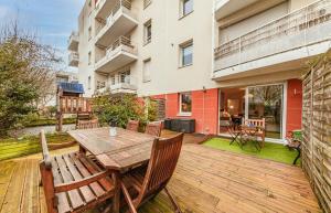 雷恩Le Saint Cyr - bel appartement, parking & terrasse的木制甲板配有木桌和椅子