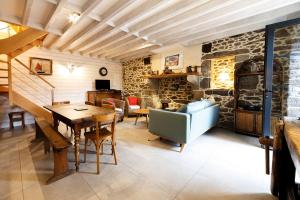 圣马洛Minihic - Belle maison 3 chambres- Proche Mer的一间设有桌子和石墙的用餐室