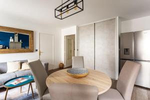 雷恩Le Saint Helier -Appartement Cosy et calme Parking的厨房以及带木桌和椅子的客厅。