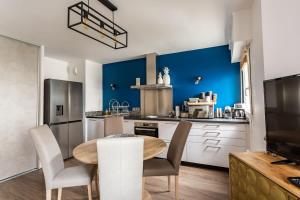 雷恩Le Saint Helier -Appartement Cosy et calme Parking的厨房配有桌子和蓝色的墙壁