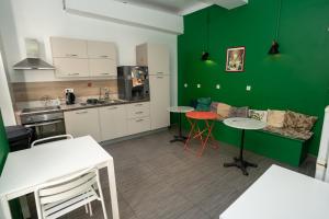 尼斯Le Pastoral的厨房拥有绿色的墙壁和桌椅