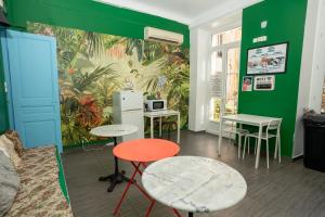 尼斯Le Pastoral的配有桌椅和绿色墙壁的客房
