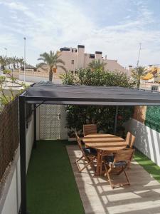 阿勒纳勒斯德尔索尔Costamar playa arenales del sol的屋顶上带桌椅的天井