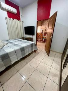 吉巴拉那Casa para o Rondônia Rural Show的一间卧室配有一张床和一台平面电视