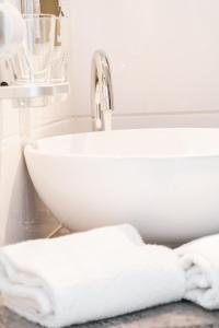施塔特韦伦Manufaktur Boutique Hotel的浴室水槽和台面上的白色毛巾
