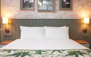 罗克瑟姆The Kings Head Wroxham by Greene King Inns的一间卧室配有一张带两盏灯的大型白色床。