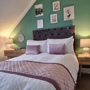 奥本Rose Villa的一间卧室设有一张带绿色墙壁的大床