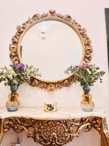UclésPuerta del Agua的花朵花桌上的华丽金色镜子