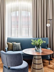 华沙Hotel Verte, Warsaw, Autograph Collection的客厅配有蓝色的沙发和桌子