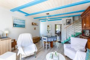 康卡勒Ker Roz - Belle maison 3 chambres- Proche Mer-Port的客厅配有白色椅子和蓝色天花板