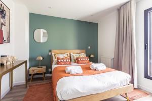 迪纳尔Villa Ty Laouen- Maison moderne 3 chambres jardin的一间卧室配有一张带橙色毯子的大床
