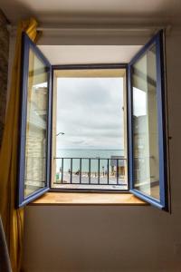 康卡勒La Brise- Joli T2 rénové - Vue Mer - 1 chambre的享有海滩景致的开放式窗户