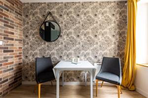 康卡勒La Brise- Joli T2 rénové - Vue Mer - 1 chambre的一间带桌子、两把椅子和镜子的用餐室