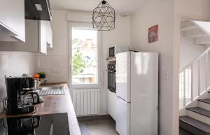 圣马洛Le Gardelle - Jolie maison de ville (2 chambres)的厨房配有白色冰箱和窗户。